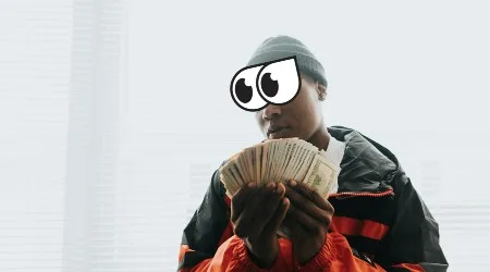 Man in Orange and Black Jacket Holding Plenty of Money