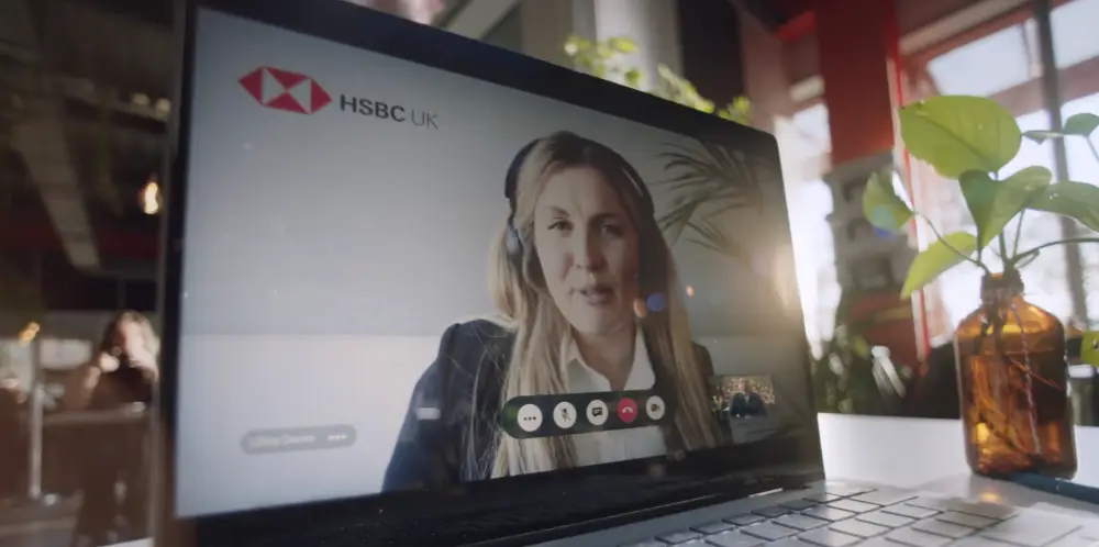 A bank providing virtual expert support to a small business owner at a shared workspace.