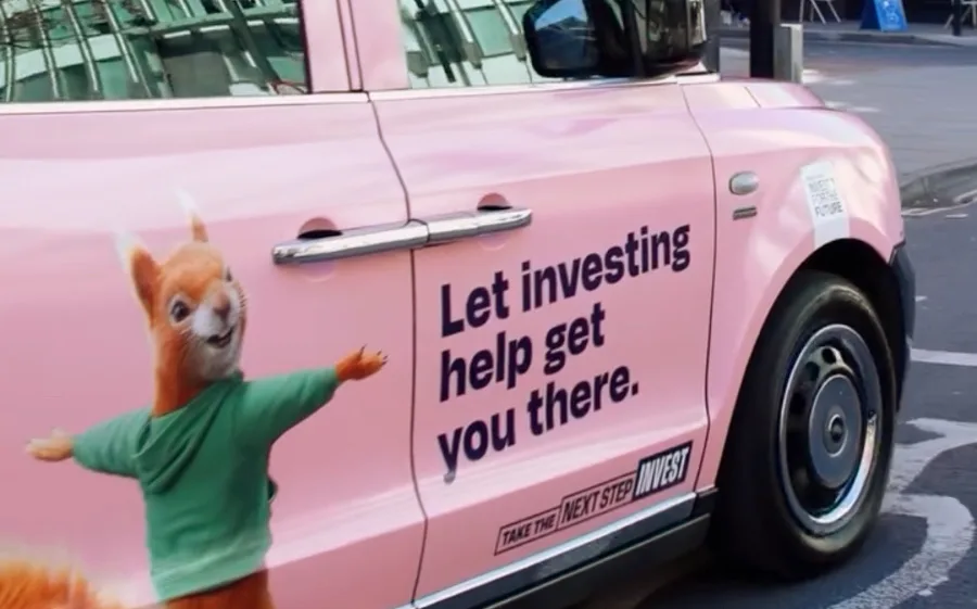 The side of a taxi cab in Manchester which has been decorated to promote the UK government's 'Take the next step invest' campaign, featuring Savvy the Squirrel.
