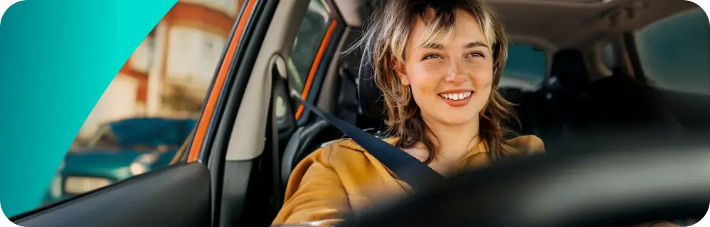 a close-up of a girl driving a car smiling