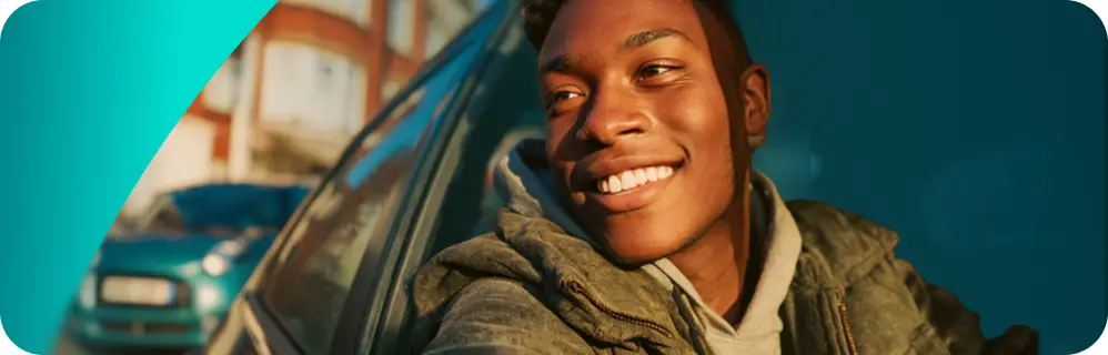 a close-up of a boy driving a car smiling