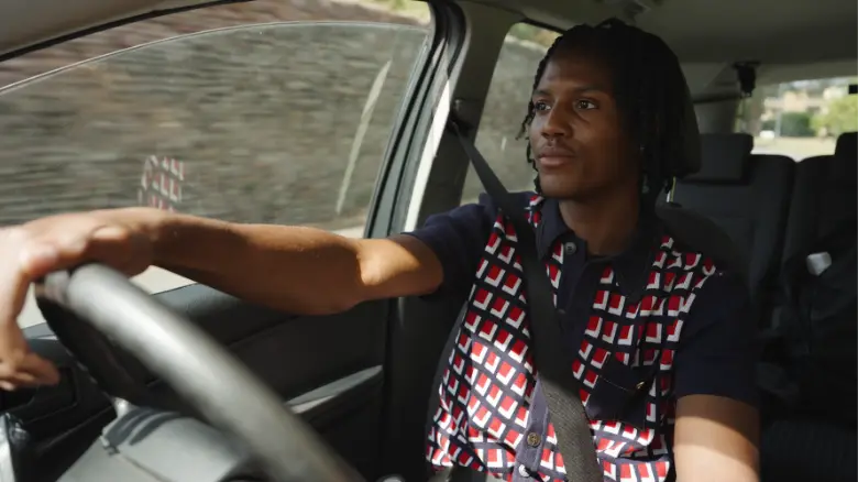 a close-up of a girl driving a car smiling