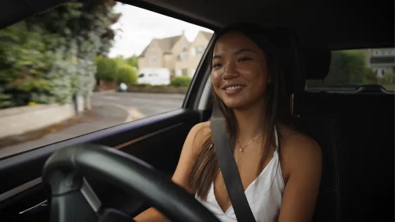 a close-up of a boy driving a car smiling