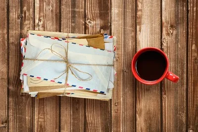 Pile of mail next to coffee cup