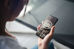A person holding a smartphone that displays a "Cash Back" icon on the screen.