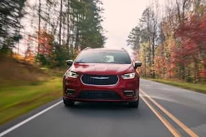 Red Chrysler Pacifica EV driving on road