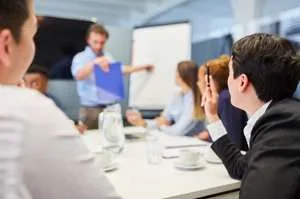 A group of professionals sitting at a long table in a seminar room.