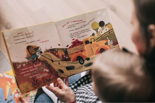 Woman reading a book to a toddler