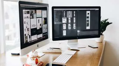 A clean, flat-lay arrangement of various tech devices including a laptop, smartphone, tablet, and headphones on a white surface.
