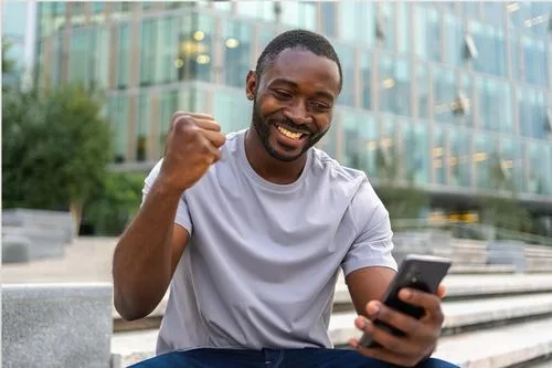 Happy man looking at his phone width=