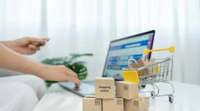 A person shopping online using a smartphone and a laptop