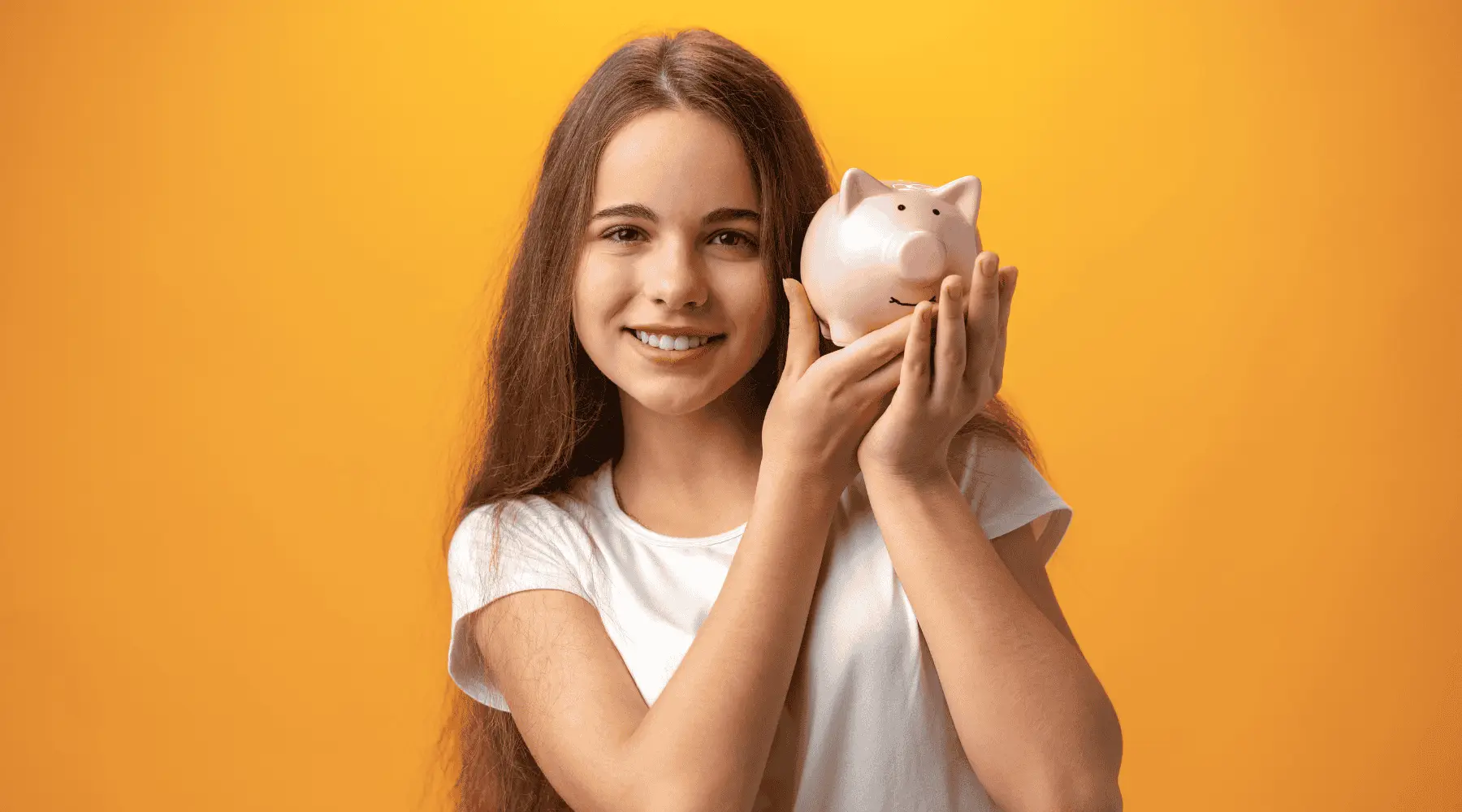 Teen girl holding piggy bank