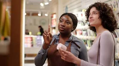 A woman seller showing products on display to a client
