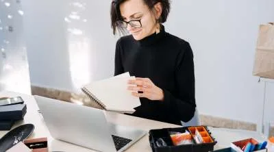 A creator in their home studio, looking some notes.