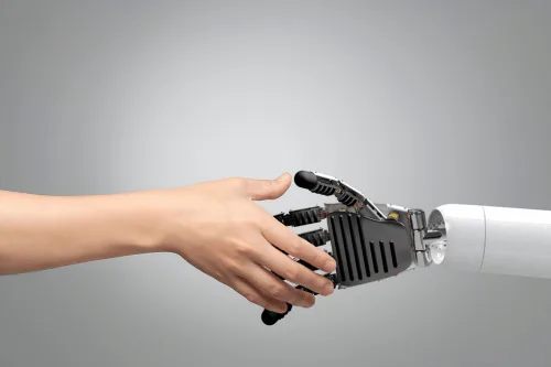 Human hand shaking a robot hand